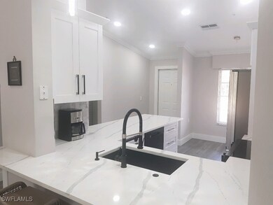 Kitchen featuring white cabinets, ornamental moldi
