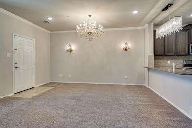 Unfurnished living room with crown molding, light carpet, baseboards, visible vents, and an inviting chandelier