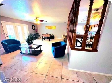 Living area featuring light tile patterned flooring, ceiling fan, and healthy amount of natural light