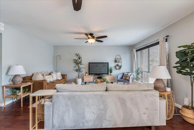 Living area featuring baseboards, a ceiling fan, 