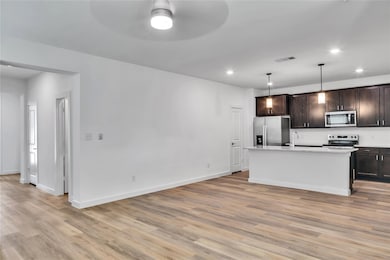 Kitchen featuring dark brown cabinets, appliances 