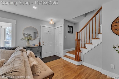 Entrance foyer with light oak wood flooring, recessed lighting, and stairs