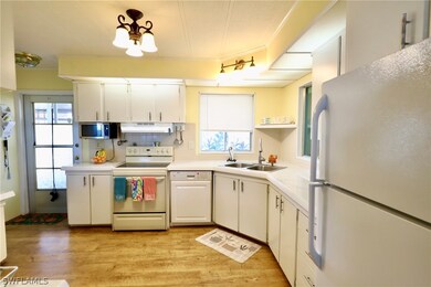 Kitchen with sink, white appliances, white cabinet
