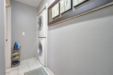 Washroom with light tile patterned floors, laundry