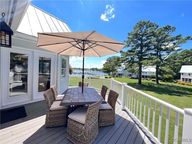 Wooden deck featuring a water view and a lawn