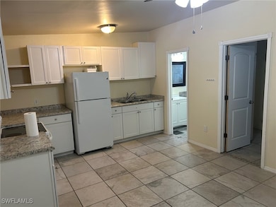 Kitchen featuring freestanding refrigerator, open