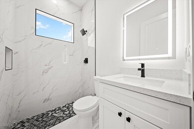 Bathroom with vanity and a marble finish shower