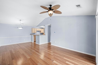Unfurnished living room featuring vaulted ceiling,