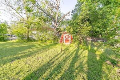 View of yard featuring a shed, fence, and an outbu