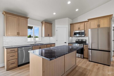 Kitchen with appliances with stainless steel finishes, a center island, light wood-style flooring, backsplash, and recessed lighting