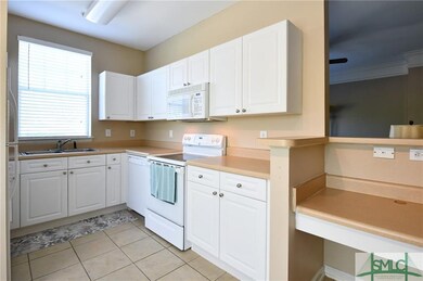 Very efficient kitchen with white cabinetry and bu