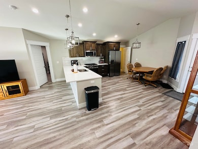 Kitchen with dark brown cabinets, recessed lighting, backsplash, stainless steel appliances, and a peninsula