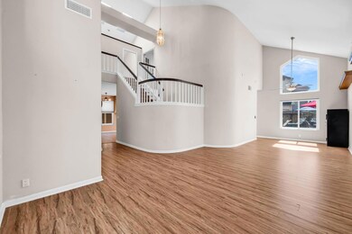 Living rm/dining room combo showing open staircase