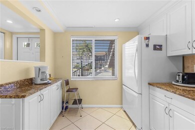 Kitchen with white cabinets, light tile patterned 