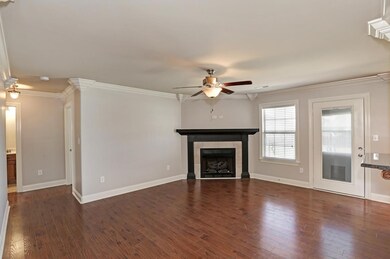 Living Room - With laminate flooring, crown molding, ceiling fan and gas log fireplace.