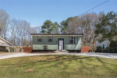 Raised ranch featuring driveway, fence, a front la