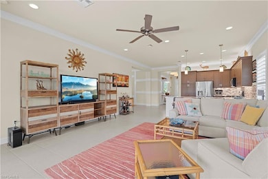Living room with ornamental molding, light tile patterned floors, recessed lighting, and ceiling fan