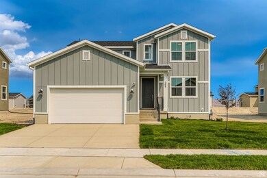 Craftsman-style home with board and batten siding, a front lawn, concrete driveway, and an attached garage