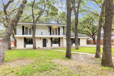 View of front of house with a balcony and a front lawn