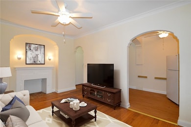 Virtually Staged Living room with a ceiling fan, ornamental molding, wood finished floors, and a fireplace