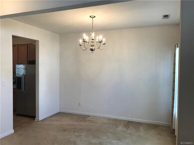 View of formal dining room with chandelier, carpet