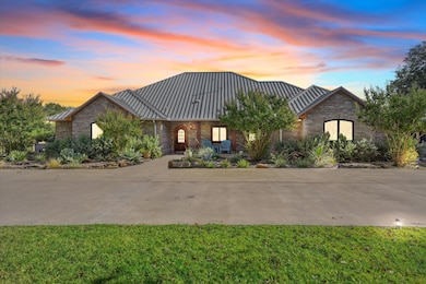 View of front facade with a standing seam roof, a metal roof, and stone siding