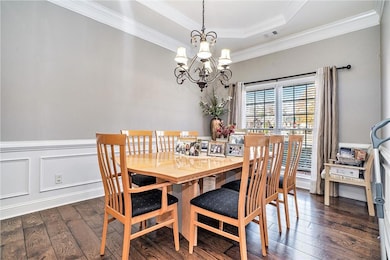 Dining room featuring a raised ceiling, crown mold
