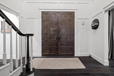 Entrance foyer featuring baseboards, dark wood-st