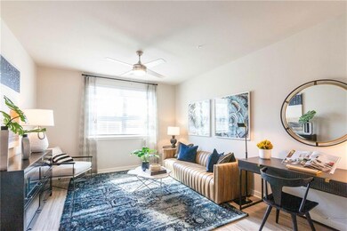 Living room featuring ceiling fan and light wood-t