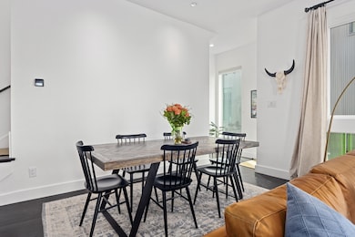 Dining area with dark wood-type flooring, recessed lighting, and stairway