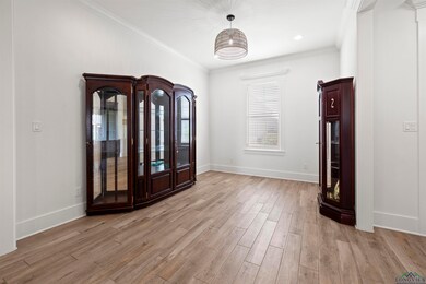 Foyer entrance with light wood-style floors and ornamental molding