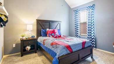 Bedroom with light colored carpet and vaulted ceil