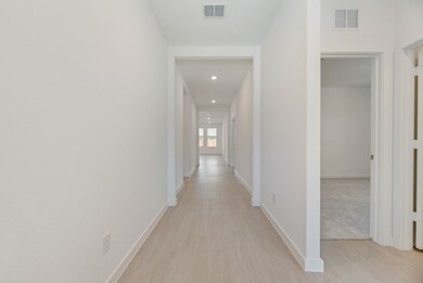 Hall with light wood-style floors and recessed lighting