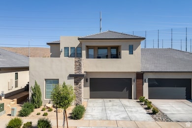 View of front of property with concrete driveway, a garage, stucco siding, a tile roof, and a balcony