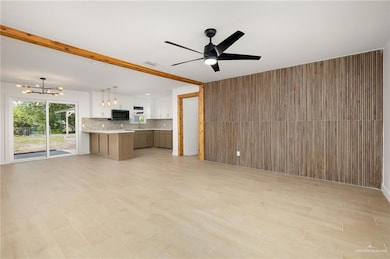 Unfurnished living room featuring visible vents, light wood-type flooring, and ceiling fan with notable chandelier
