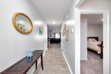 Corridor featuring light colored carpet