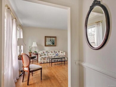 The formal living room is just off to the left and also features hardwood floors and crown molding