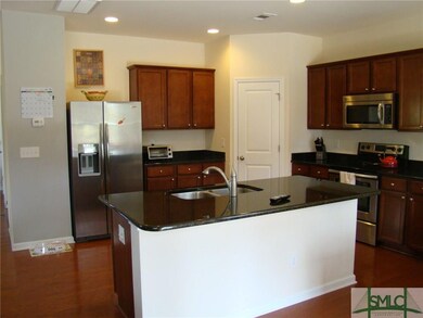 Kitchen features wood flooring, stainless applianc