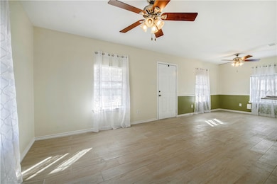 Spare room with plenty of natural light, light wood-style flooring, and ceiling fan