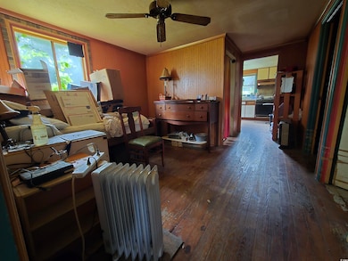Office area with hardwood / wood-style flooring, radiator, and a ceiling fan
