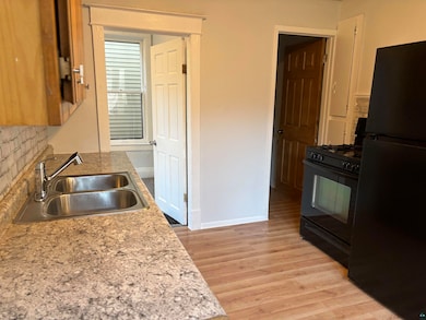 Kitchen with tasteful backsplash, sink, black appl