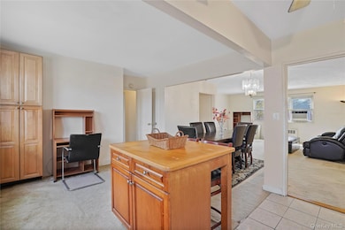 Kitchen with light carpet, wood counters, open floor plan, light tile patterned floors, and decorative light fixtures