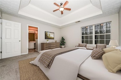 Carpeted bedroom featuring a textured ceiling, vis