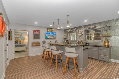 Indoor wet bar with carpet floors, recessed lighting, baseboards, and hanging light fixtures