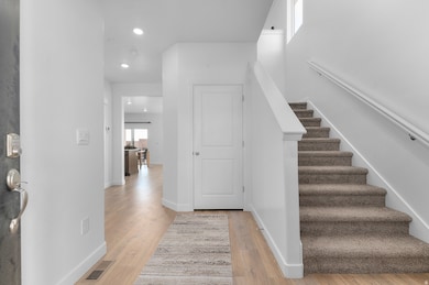 Foyer entrance with light wood-style flooring, recessed lighting, and stairway