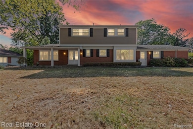 Colonial house with brick siding and a front yard