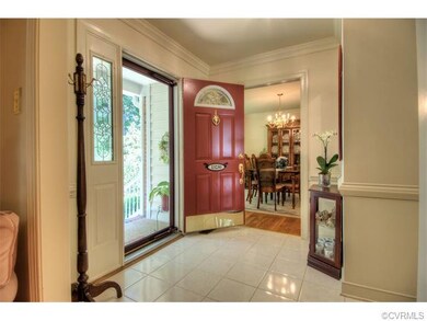 Large foyer with crown moulding and tiled flooring