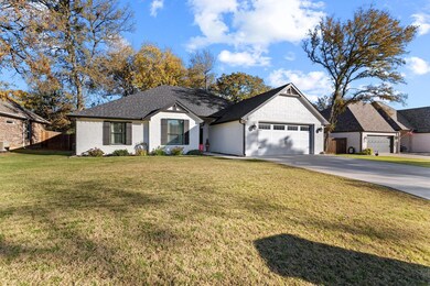 View of front of property featuring brick siding, driveway, and a garage