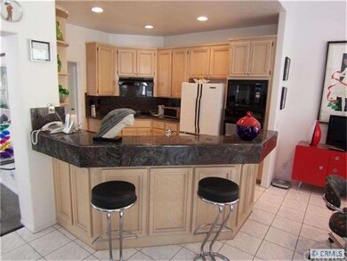 View of kitchen & eat-at bar (note lovely granite)