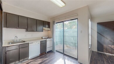 Kitchen featuring dark brown cabinetry, white appl
